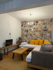 a living room with a couch and a tv at Angel's Luxury Studio in Olympiada