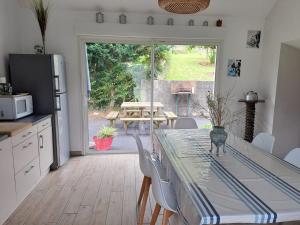 a kitchen with a table and chairs and a kitchen with a table and a door at location gite chez DENIS in Alçay-Alçabéhéty-Sunharette