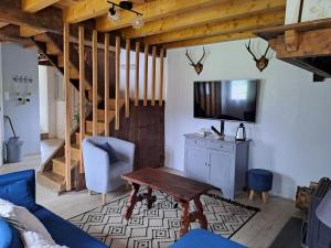 a living room with a blue couch and a tv at location gite chez DENIS in Alçay-Alçabéhéty-Sunharette