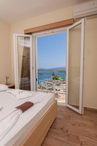sypialnia z łóżkiem i balkonem z widokiem na ocean w obiekcie Villas Odysseas w mieście Nydri