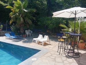 a pool with chairs and a table and an umbrella at Vega Fuente de las Moreras in Burunchel