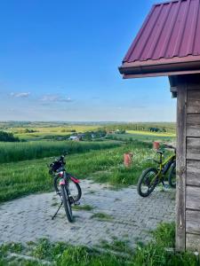 two bikes are parked next to a building at Domek Na Wzgórzu Roztocze in Majdan Abramowski