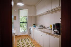 a kitchen with white cabinets and a large window at Glow Central Apartment Eminescu in Târgu-Mureş