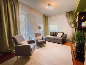 a living room with two chairs and a couch at Glow Central Apartment Eminescu in Târgu-Mureş