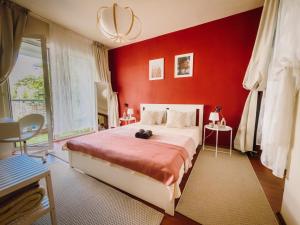 a bedroom with a large bed with red walls at Glow Central Apartment Eminescu in Târgu-Mureş
