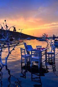 a table and chairs in the water at sunset at DaSH EV in Bodrum City