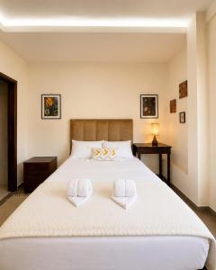 a bedroom with a large white bed with towels on it at Sarao in Santa Cruz de la Sierra