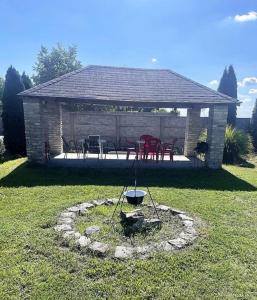 a pavilion with a table and chairs in a yard at Apartmány Harmónia in Veľký Meder