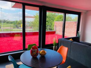 a table and chairs in a room with a large window at Tommorowland Apartement in Boom