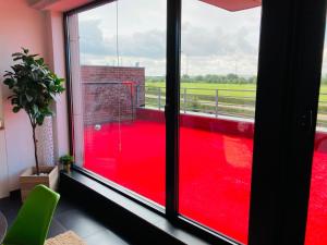 a room with a red floor and a window at Tommorowland Apartement in Boom +1 photo
