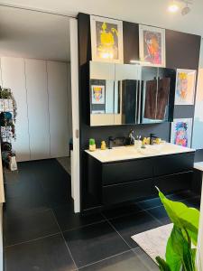 a bathroom with a white sink and a black floor at Tommorowland Apartement in Boom
