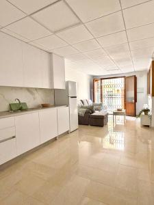 a kitchen with white cabinets and a living room at Casa Placeta Serna in Vélez-Rubio
