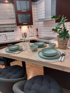 a table with plates and bowls on it in a kitchen at Angel's Luxury Studio in Olympiada