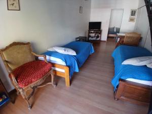 a room with two beds and a chair at SL 1908 in Olivos