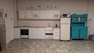 a kitchen with white appliances and blue cabinets at Loft in Funes