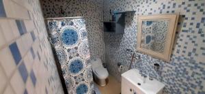a blue and white bathroom with a toilet and a sink at Loft in Funes