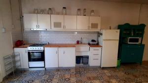 a kitchen with white cabinets and white appliances at Loft in Funes