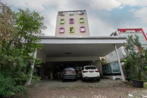 two cars parked in a garage with a building at Hotel Aleander By ARBA in Jakarta