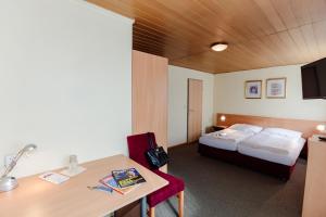 フォルヒドルフにあるHotel Denk Bed & Breakfastのベッド、デスク、テーブルが備わる客室です。