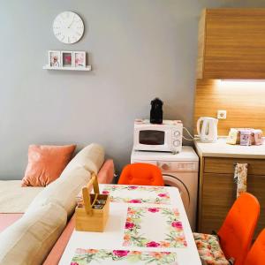 a room with a couch and a table and a microwave at Студио Стайл - Соренто Соле Маре in Sveti Vlas