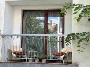 a balcony with chairs and a table and a window at Glow Central Apartment Eminescu in Târgu-Mureş