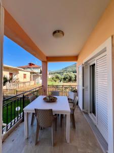 a patio with a table and chairs on a balcony at Akratas Brothers House in Akrata