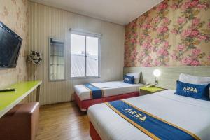 a hotel room with two beds and a window at Hotel Aleander By ARBA in Jakarta +42 photos