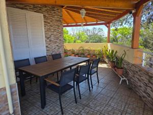 a wooden table and chairs on a patio at Lúcia's House in Santa Cruz