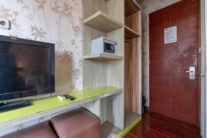 a room with a flat screen tv and a door at Hotel Aleander By ARBA in Jakarta