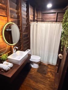 ein Badezimmer mit Waschbecken, Toilette und Spiegel in der Unterkunft Cabañas Alebrije in Celestún