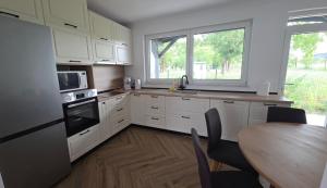 a kitchen with white cabinets and a table and a window at MarioLia Comfort Residence in Oradea