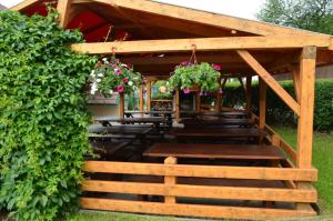 a wooden pergola with benches and flowers on it at Penzion Horal in Osek