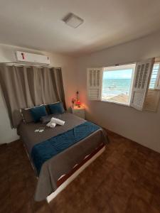 a bedroom with a bed and a view of the ocean at Barra lounge in Maragogi