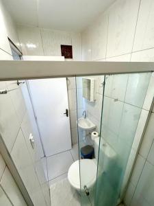 a white bathroom with a toilet and a sink at Barra lounge in Maragogi +50 photos