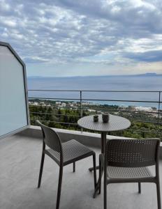 a table and chairs on a balcony with the ocean at Nostos Palase in Dhërmi