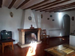 a living room with a fireplace and a tv at Casa Rural El Cortijo Nuevo, en El Cerezo in El Cerezo