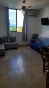 a living room with a blue couch and a large window at Apartamentos en coveñas in Coveñas