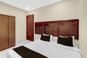 a bedroom with a large white bed with black pillows at HOTEL O INNORA in Raipur +118 photos