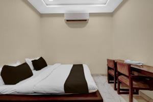 a bed in a room with a tv on the wall at HOTEL O INNORA in Raipur