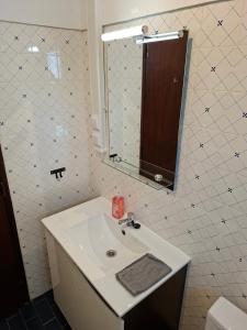 a white bathroom with a sink and a mirror at Casa Svancy in Lagoa +15 photos