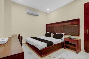 a bedroom with a large bed and a desk at HOTEL O INNORA in Raipur