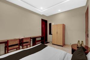 a bedroom with a bed and a desk and a table at HOTEL O INNORA in Raipur