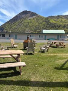 a group of picnic tables and chairs in front of a building at Le Délice Motel Restaurant in Mont-saint-pierre