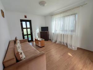 a living room with a couch and a television at Virajlux Verde Retreat in Mioveni