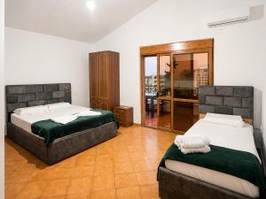 a bedroom with two beds and a balcony at Villa Sofia in Durrës