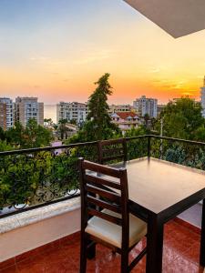 a table and chair on a balcony with a sunset at Villa Sofia in Durrës