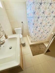 a bathroom with a tub and a toilet and a shower curtain at Mani Spot by the Sea in Gerolimenas +14 photos