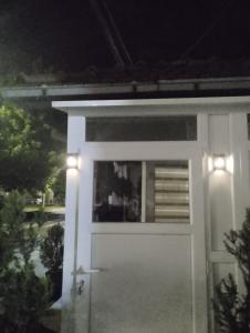 a white door with two lights on it at night at Studio Djordjevic in Kraljevo +5 photos