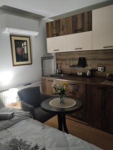 a room with a table and a bed and a kitchen at Studio Djordjevic in Kraljevo