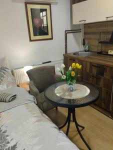a living room with a table with a vase of flowers at Studio Djordjevic in Kraljevo